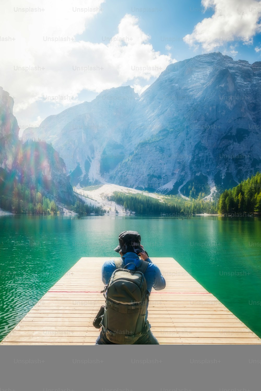 イタリアのドロミテ山脈にあるブレイズ湖(Lago di Braies)の写真を撮る旅行ハイカー。ハイキング、旅行、冒険。
