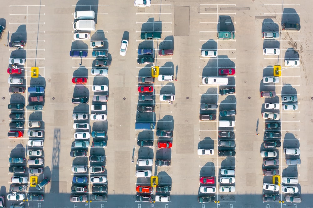 Aerial top down view of the parking lot with many cars of supermarket shoppers in the city grocery store