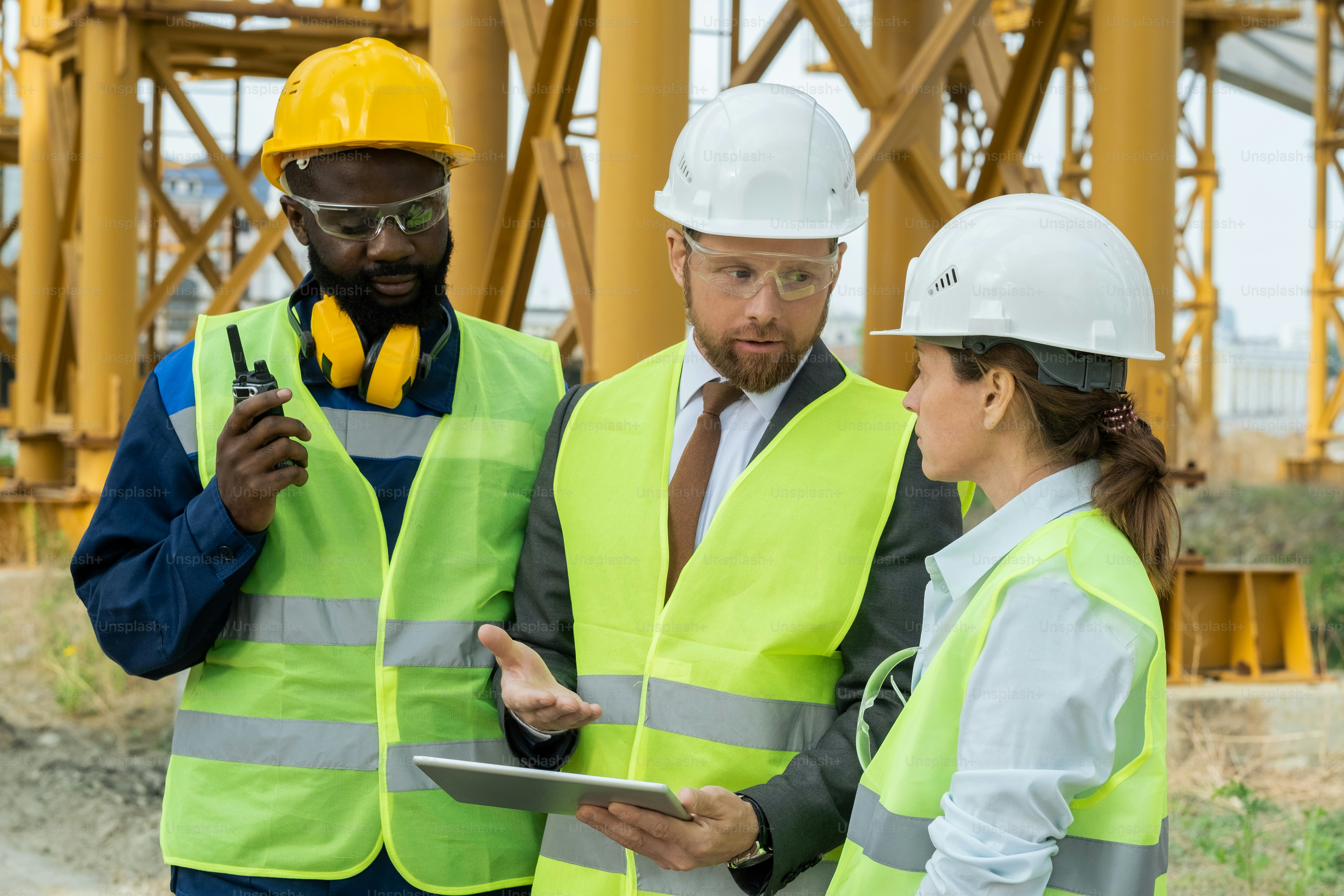 Two engineers using digital tablet and discussing project together with ...