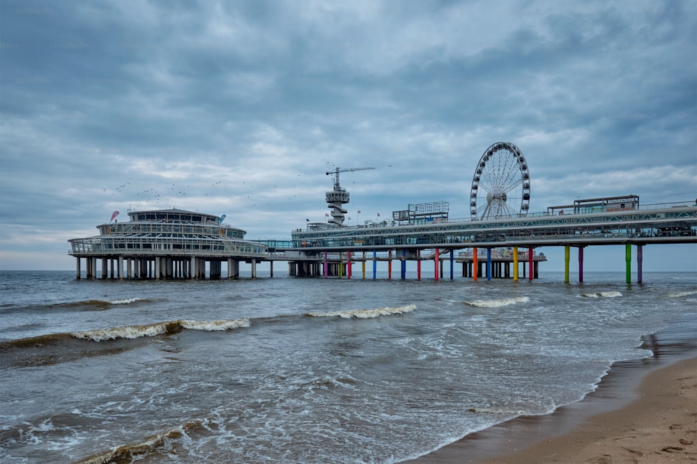 O Scheveningen Pier Strandweg, resort de praia no mar do Norte em Haia Den Haag com roda gigante. Haia, Países Baixos