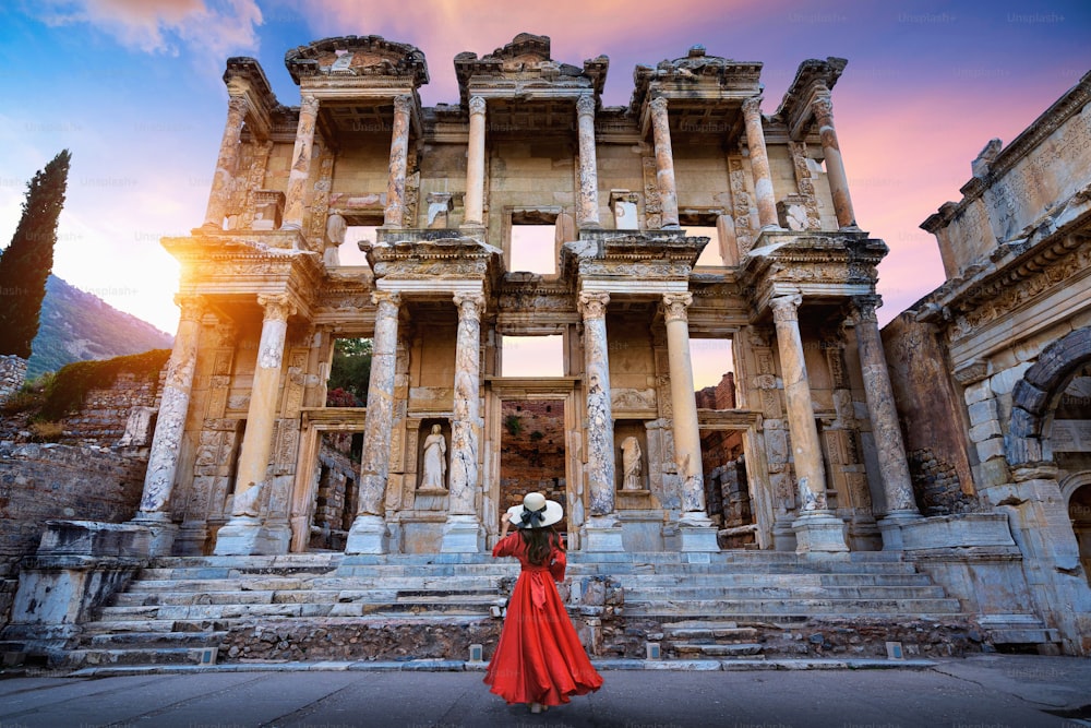 터키 이즈미르의 에베소 고대 도시에 있는 셀수스 도서관에 서 있는 여자.