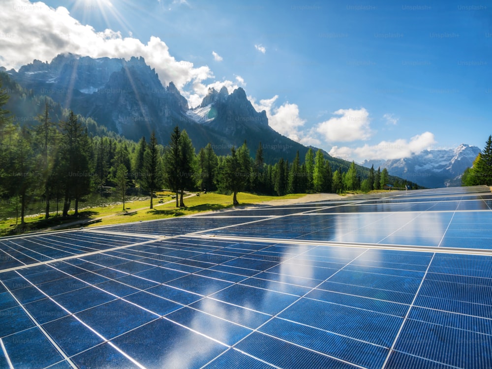 Pannello a celle solari nel paesaggio di campagna contro il cielo soleggiato e gli sfondi di montagna. L'energia solare è l'innovazione per la sostenibilità dell'energia mondiale. Risorse sostenibili.
