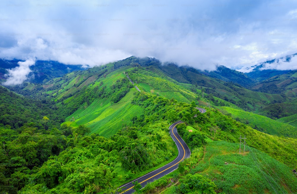 Vista aérea de la hermosa carretera del cielo sobre la cima de las montañas con la selva verde en la provincia de Nan, Tailandia.