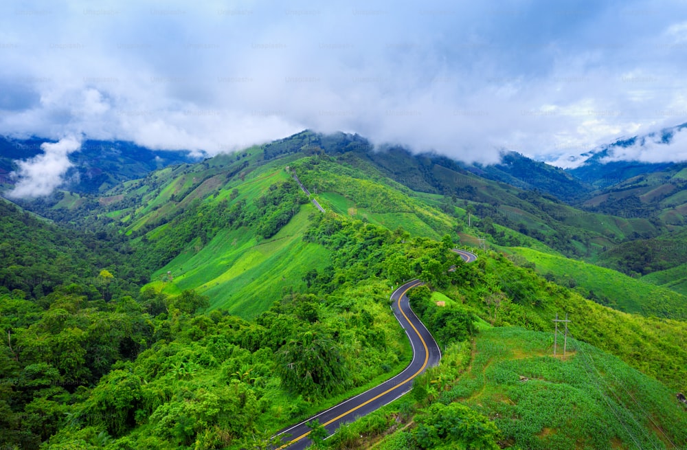 Aerial view of Beautiful sky road over top of mountains with green jungle in Nan province, Thailand.