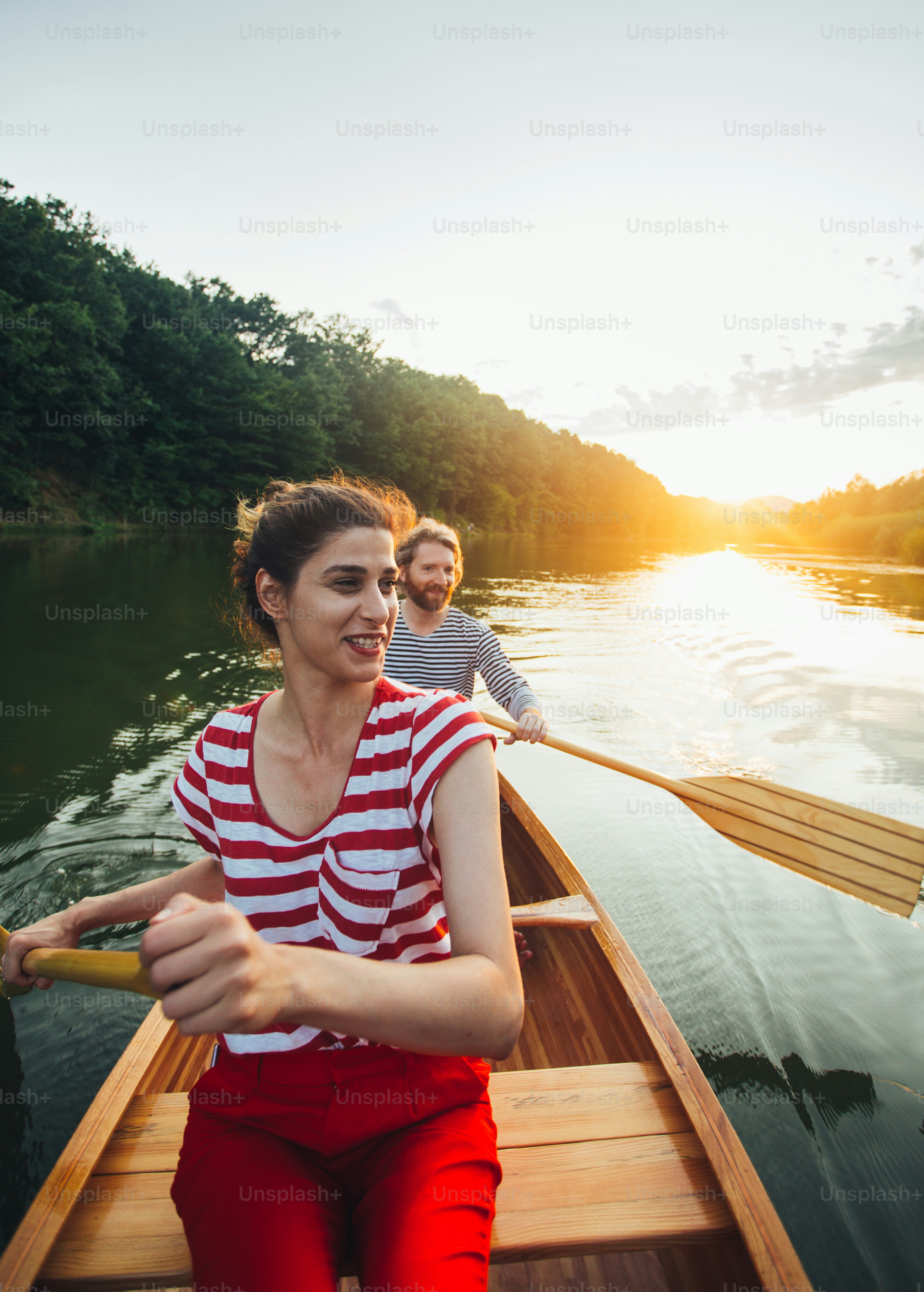 Couple enjoying canoe ride on the sunset lake.