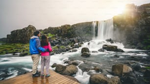 Una pareja viaja a la cascada de Oxararfoss en el Parque Nacional de Thingvellir, Islandia. La cascada de Oxararfoss es una famosa cascada que atrae a los turistas a visitar Thingvellir.