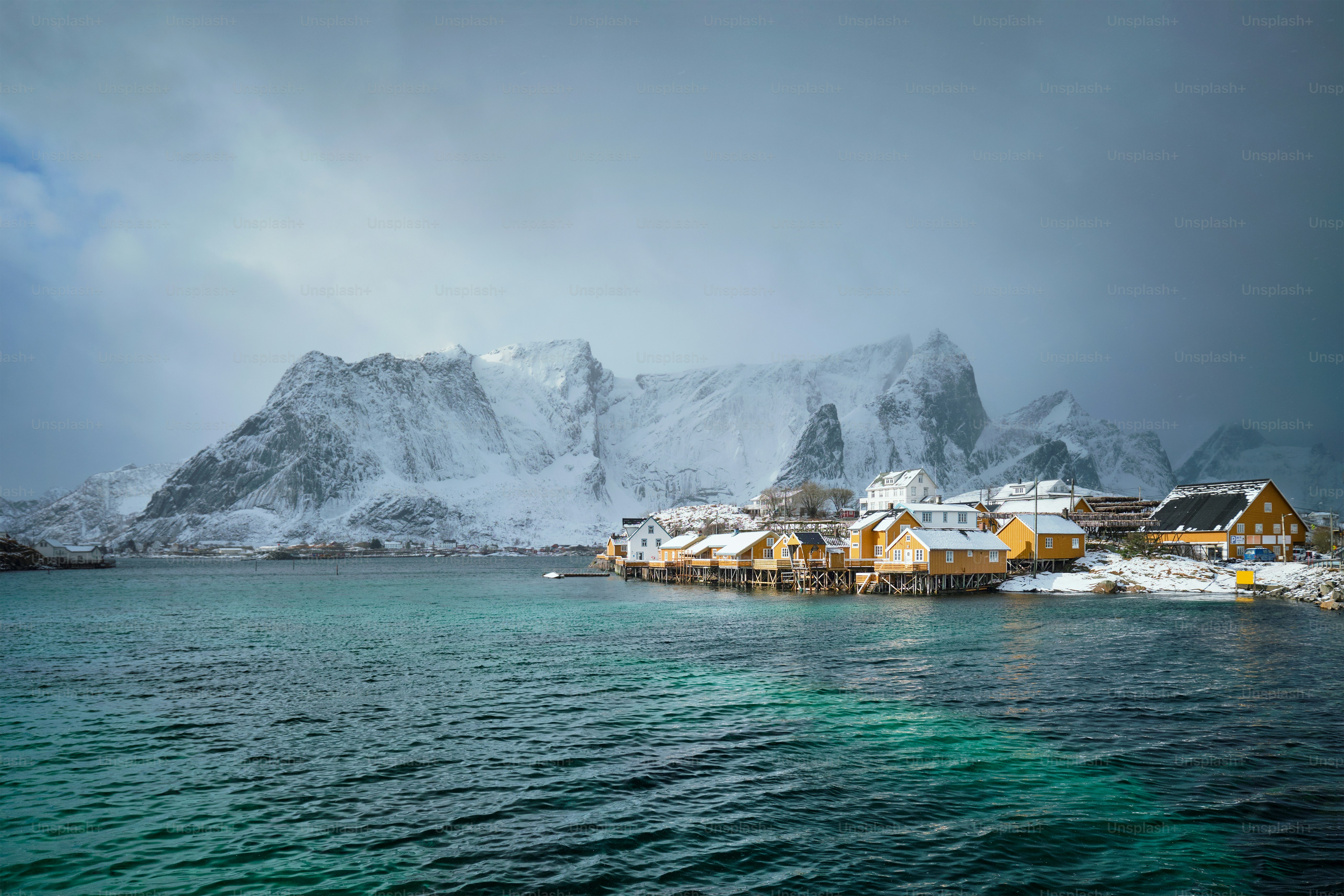 Yellow rorbu houses of Sakrisoy fishing village with snow in winter. Lofoten islands, Norway