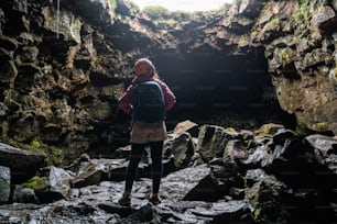 Woman traveler explore lava tunnel in Iceland. Raufarholshellir is a beautiful hidden world of cave. It is one of the longest and best-known lava tubes in Iceland, Europe for incredible adventure.