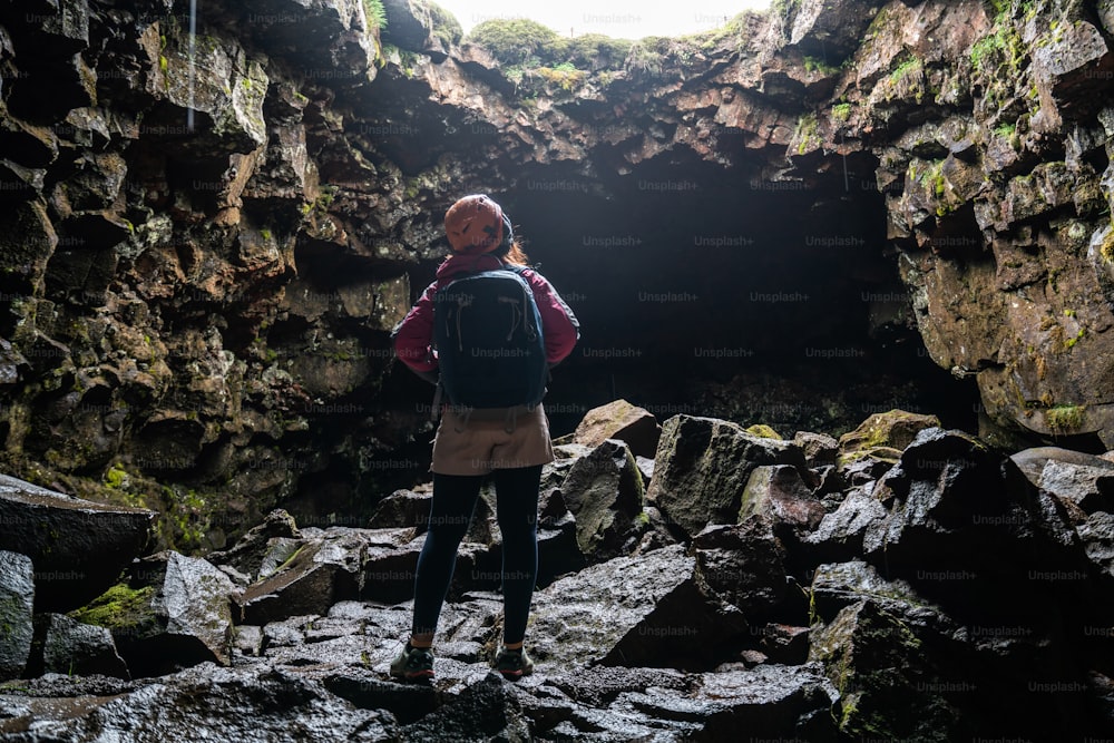 Woman traveler explore lava tunnel in Iceland. Raufarholshellir is a beautiful hidden world of cave. It is one of the longest and best-known lava tubes in Iceland, Europe for incredible adventure.