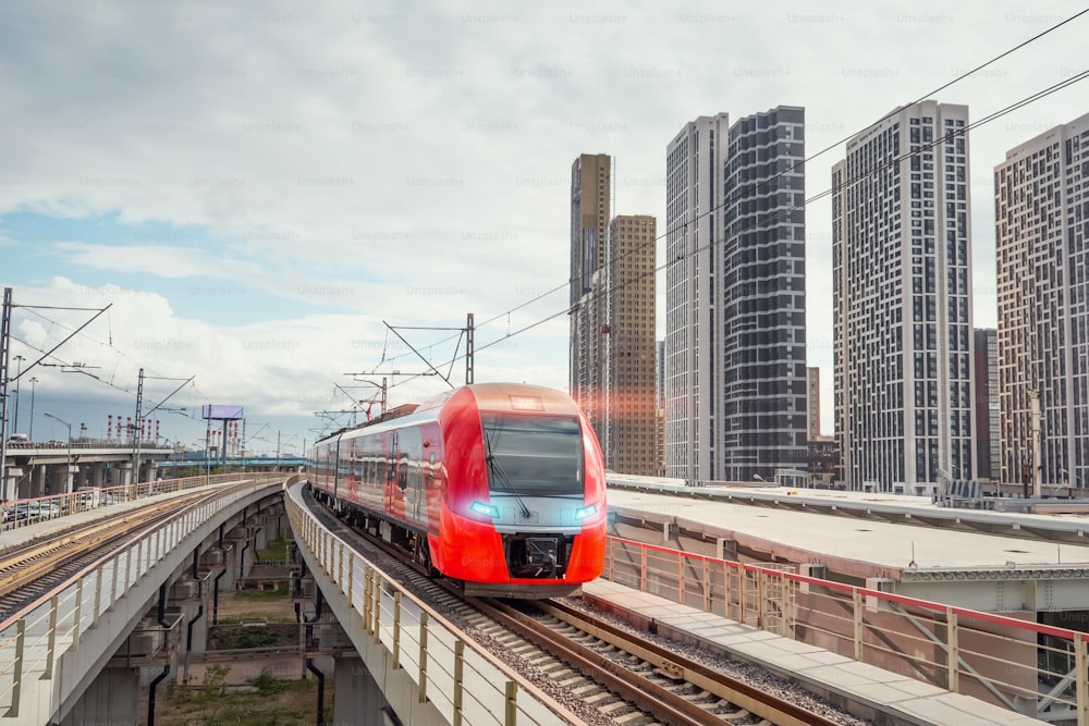 Electric passenger train drives at high speed among modern urban landscape
