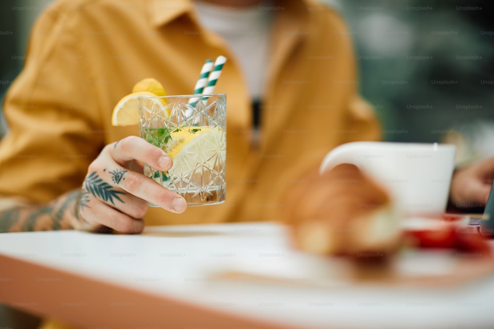 Close up of man drinking cocktail in a cafe.