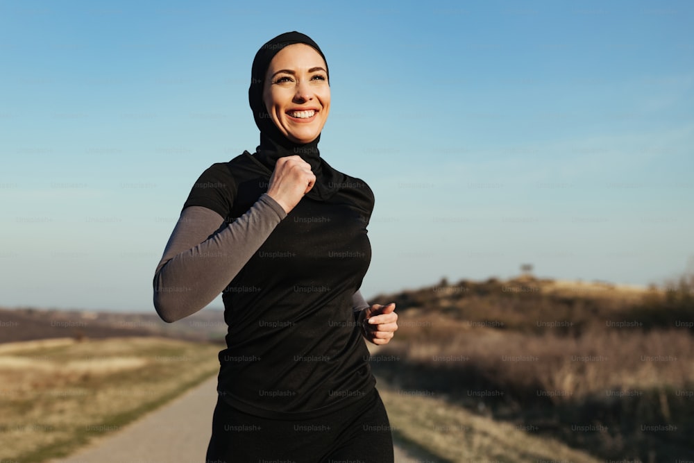 Young happy athletic woman enjoying while jogging in the morning in nature. Copy space.