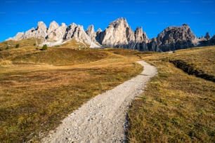 Dirt road and hiking trail track in Dolomites mountain, Italy, in front of Pizes de Cir Ridge mountain ranges in Bolzano, South Tyrol, Northwestern Dolomites, Italy.