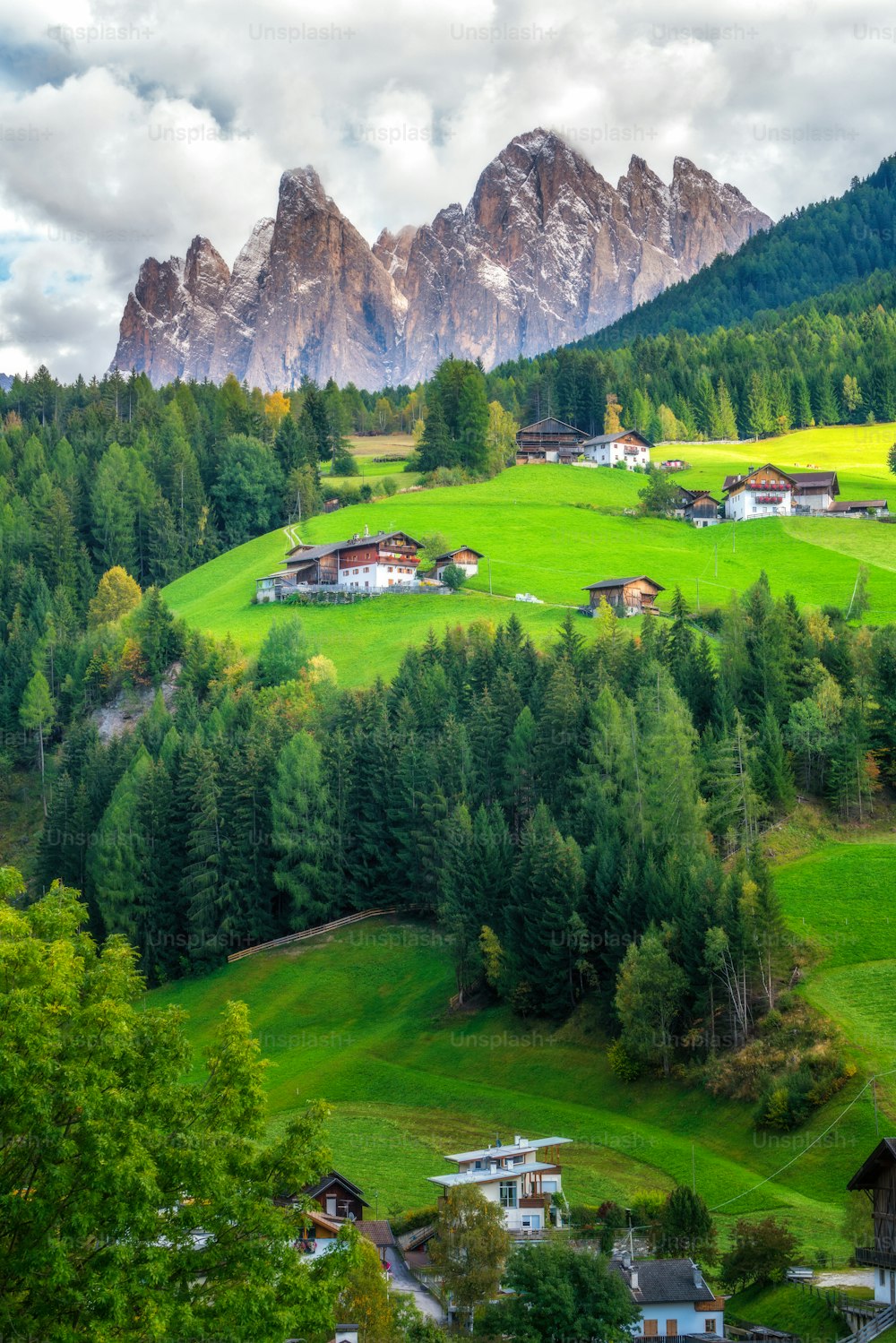 Villaggio di montagna in Val di Funes con scenario del Gruppo delle Odle nel Parco Naturale Puez-Odle, le Dolomiti nord-occidentali, Alto Adige, Italia settentrionale.