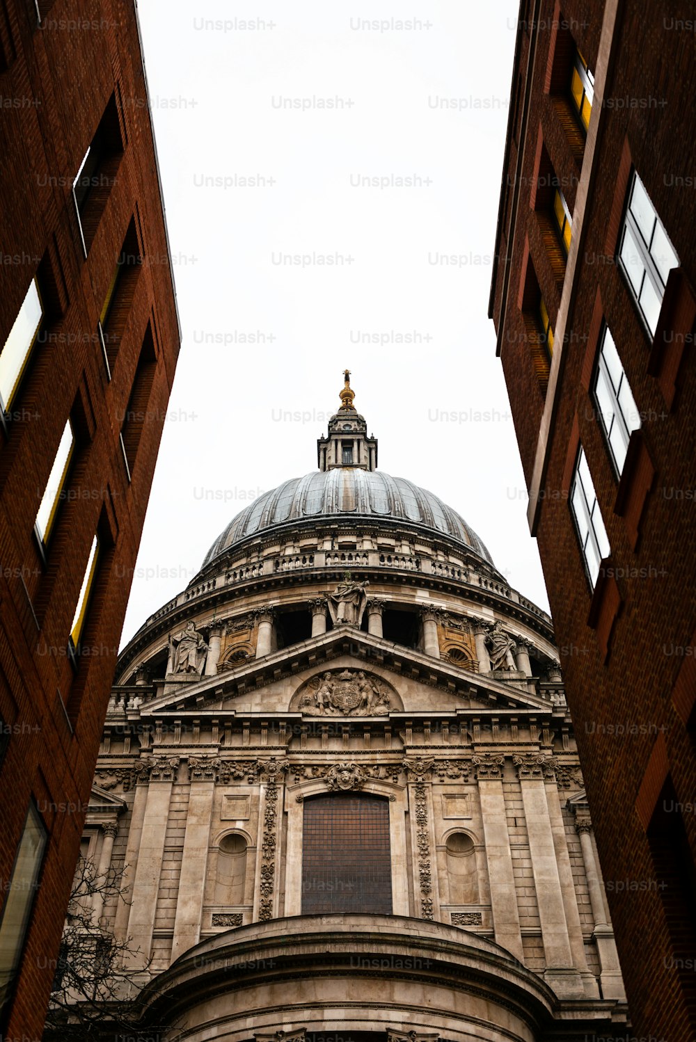 Side view of St.Paul’s Cathedral in London as seen through a narrow street. Built after The Great Fire Of London of 1666, it's Christopher Wren’s masterpiece and one of the most touristic attractions in the city.