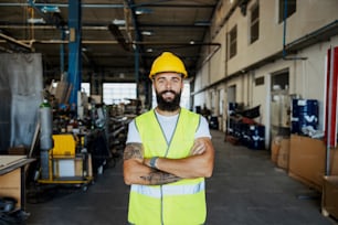 A successful manager in uniform standing with arms crossed in the garage. Worker in the garage of import and export company