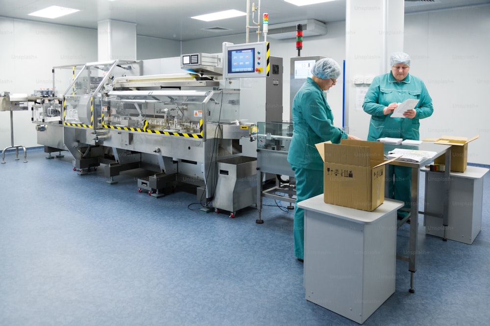 Les techniciens pharmaceutiques travaillent dans des conditions de travail stériles dans une usine pharmaceutique. Des scientifiques portant des vêtements de protection