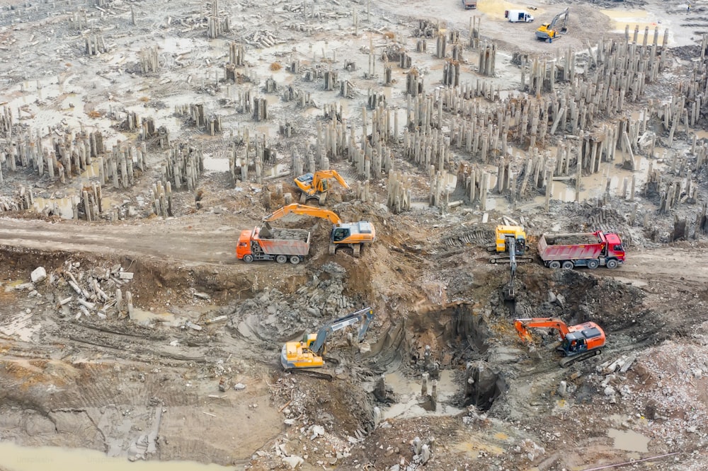 Aerial view of the pit with piles of the building, demolition. Trucks and excavators work soil removal