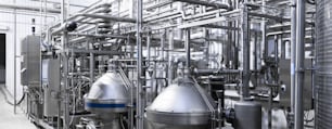 Industrial background. Equipment, industrial tools and machinery for the production in factory shops. Brewery manufacturing factory. Stainless steel vats or tanks with pipes, small equipment, modern production technology, toned