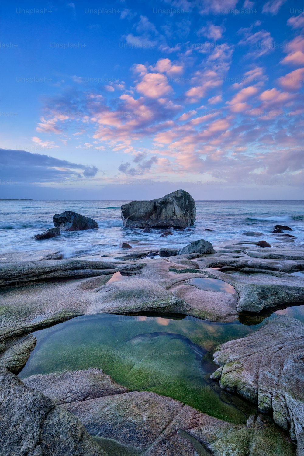 Rocks on beach of fjord of Norwegian sea in winteron sunset. Utakliev beach, Lofoten islands, Norway