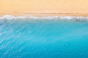 Aerial view of an idyllic sea sandy beach with blue waves and copy space. The concept of holidays in tropical countries and relaxation. Background for travel and vacation