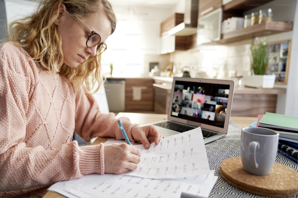 Female teacher evaluates math tasks while homeschooling