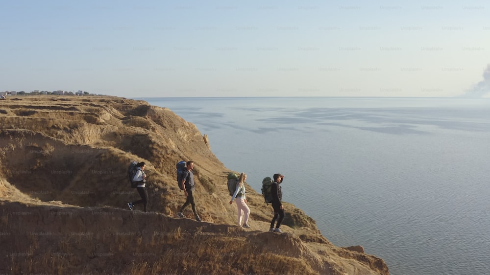 The four travelers walking on the rocky coastline