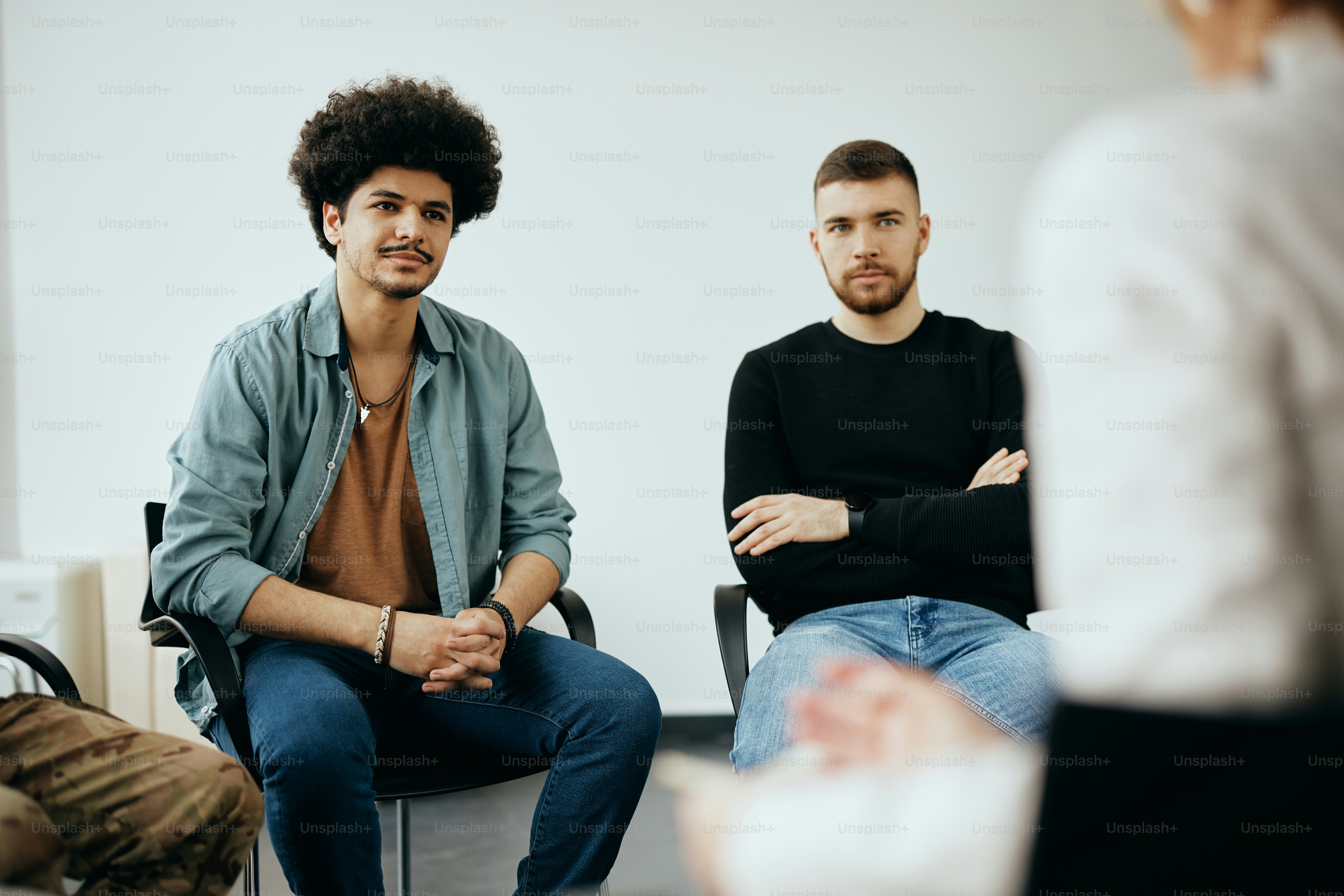 Young Muslim man attending group therapy at mental health center.