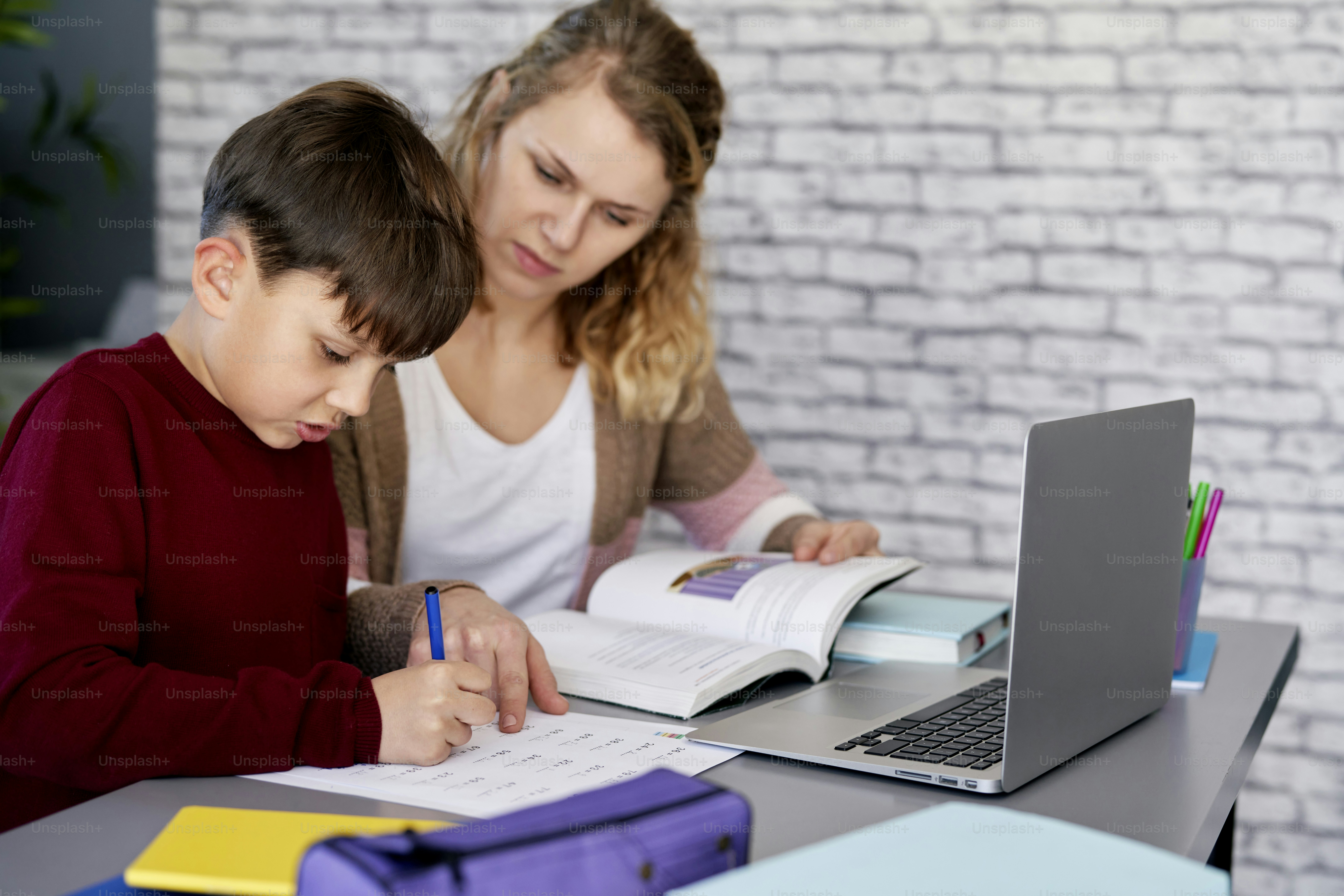 Mother helping her son with schoolwork