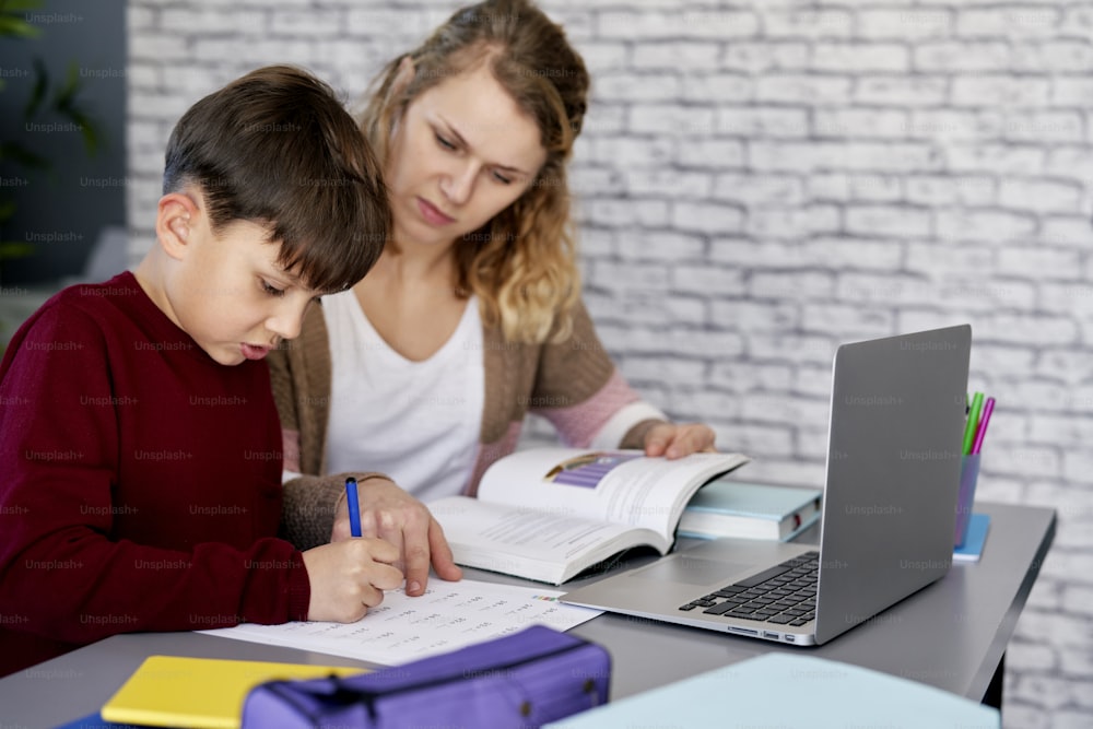 Madre ayudando a su hijo con las tareas escolares