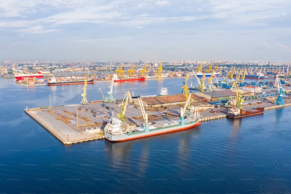 港の桟橋に係留された巨大な貨物船を空中から眺め、商品、金属、コンクリート、その他の固形原料を積み込みます