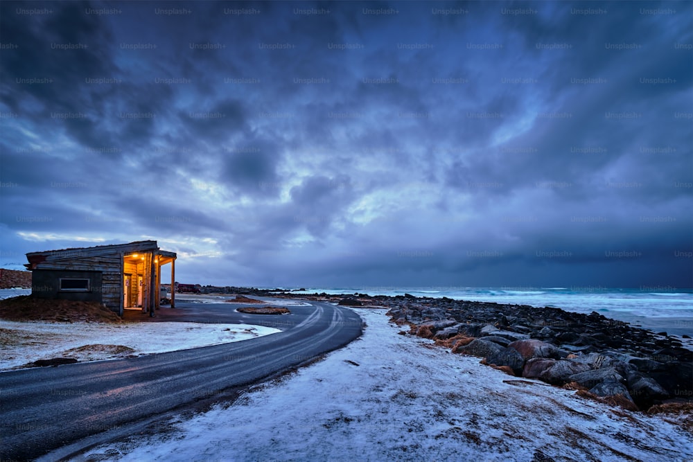 피요르드의 노르웨이 바다 연안에 있는 판잣집. 스카그산덴 해변, 플락스타드, 로포텐 섬, 노르웨이 폭풍우가 몰아치는 저녁