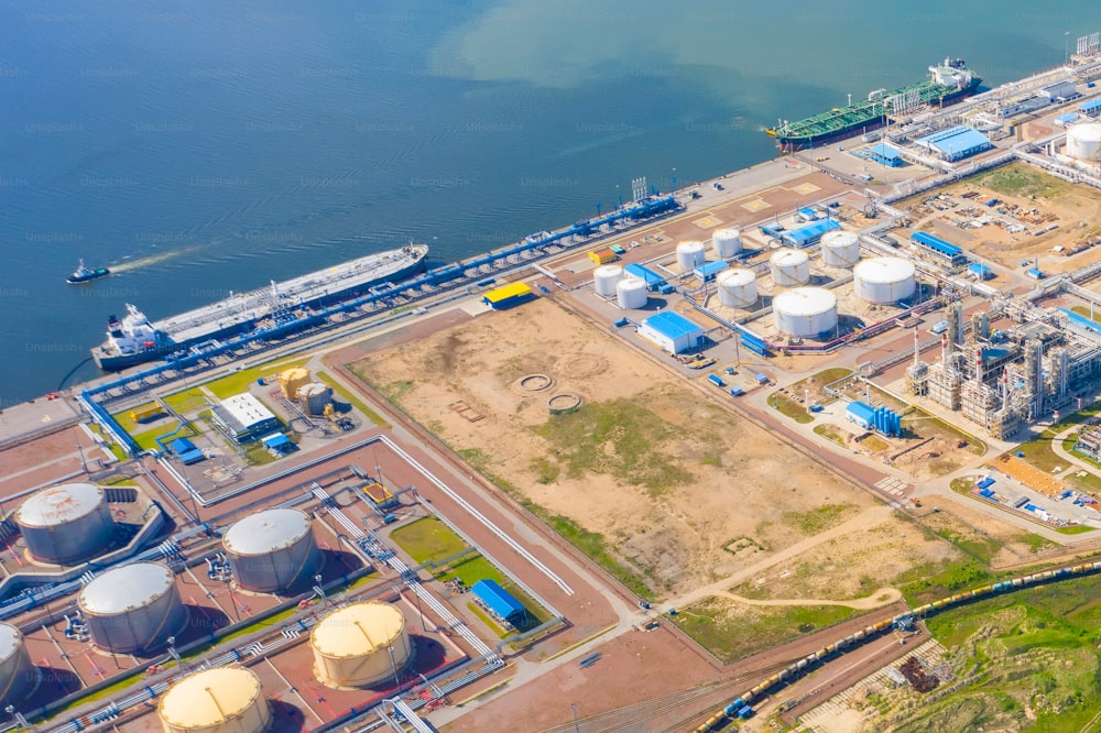 Enorme puerto con tanques de aceite para almacenar combustible líquido en la orilla del mar