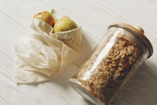 sustainable lifestyle concept. zero waste. eco natural bags with fruits and granola in glass. eco friendly, plastic free items. reuse, reduce, recycle, refuse. bulk store