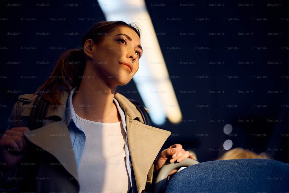 Low angle view of young woman traveling by train.