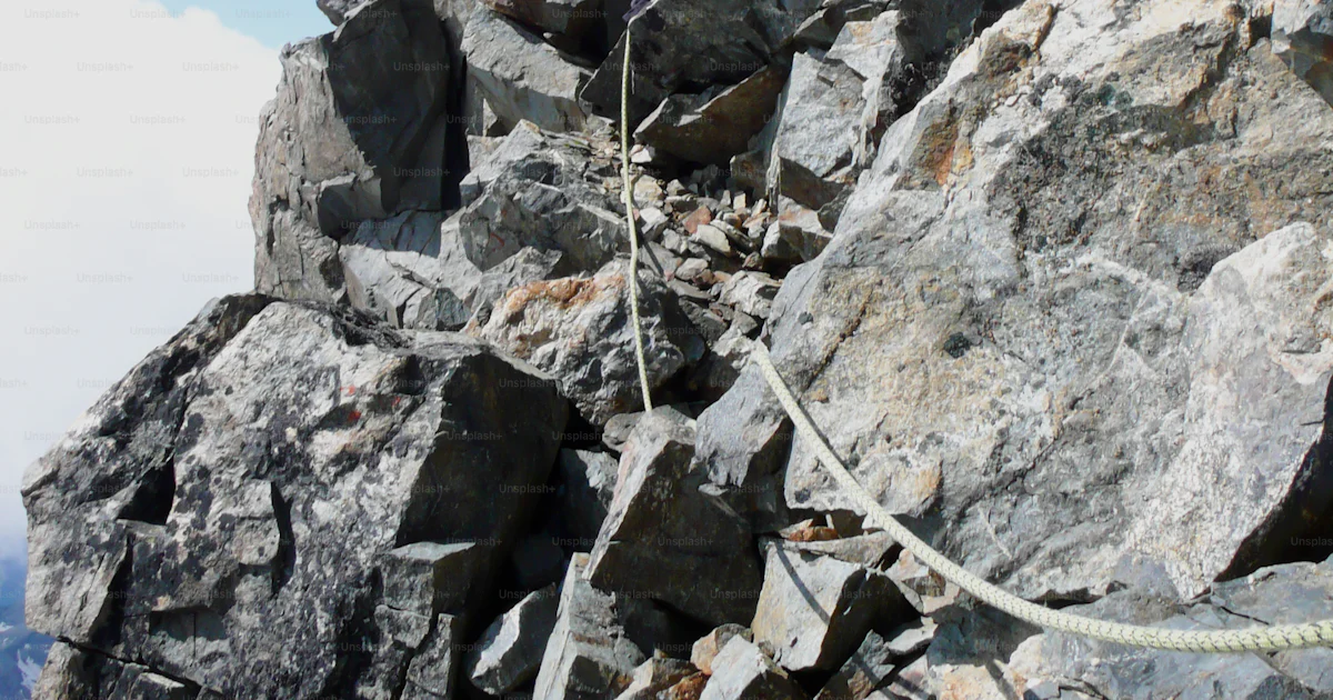 Rocky Ridge Example Mountain guide on a steep and exposed rocky ridge on his way to a high ...