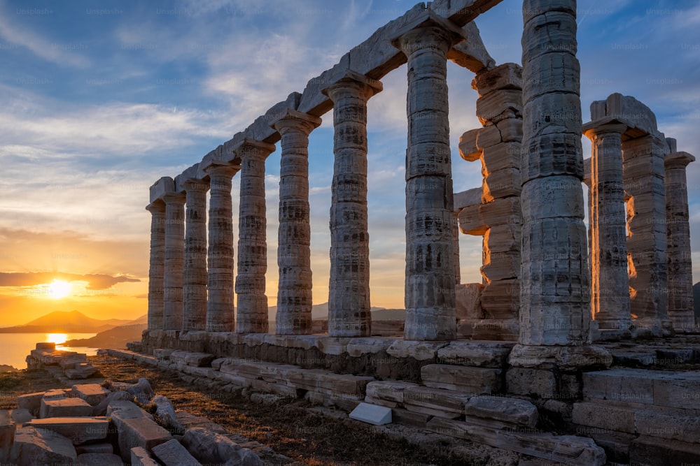 象徴的なポセイドン神殿の遺跡があるスニオンのスーニオ岬の夕日。古代ギリシアの宗教と神話に登場するオリンポスの十二神の一人。海の神様、地震。エーゲ海沿岸、ギリシャ。