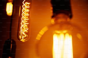 Set von Vintage-Glühbirne auf orangefarbenem Hintergrund, weicher Fokus. Glühende Edison-Glühbirne