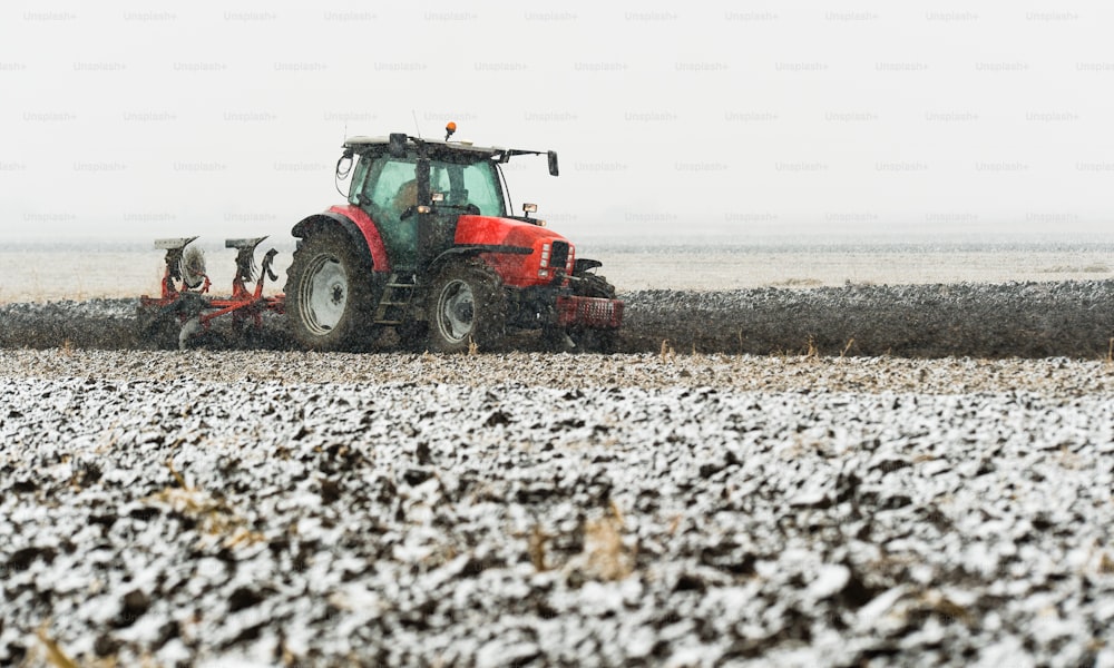 Traktor pflügt im Winter ein Feld