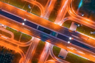 Intersezione di due principali autostrade, intersezione sotto un ponte, vista aerea notturna dall'alto dell'illuminazione stradale