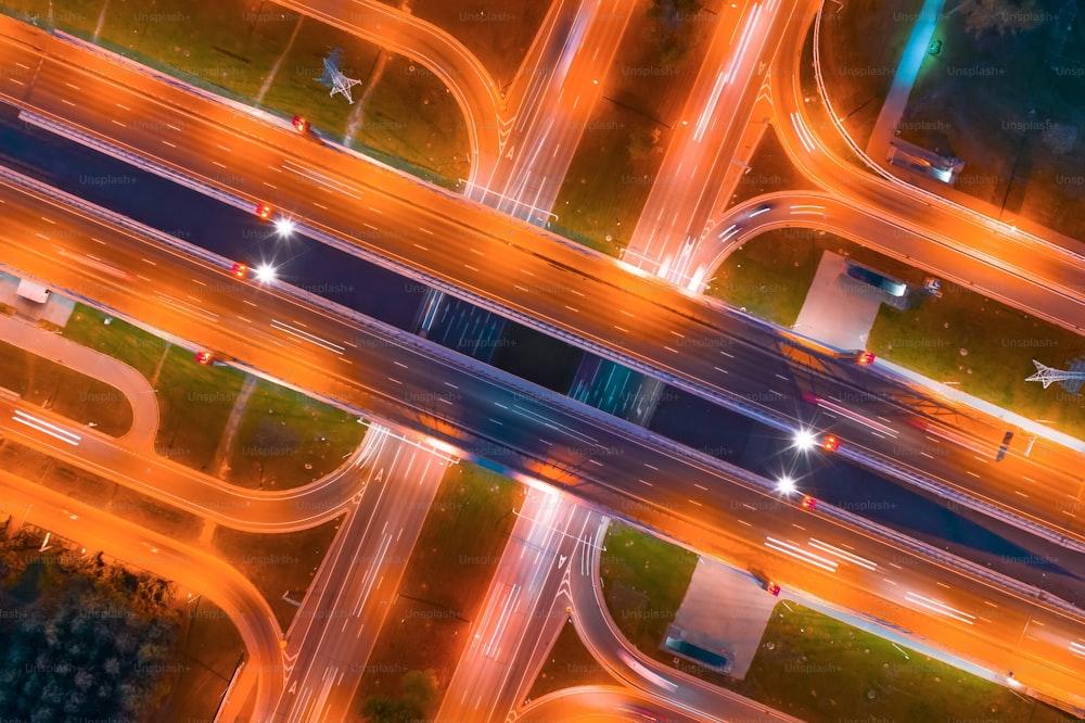 Intersection of two major highways, intersection under a bridge, night aerial top view of street lighting