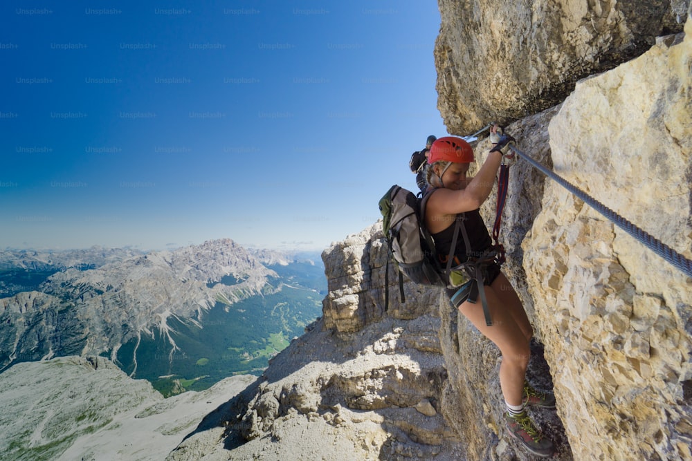 two female mountain climbers on very exposed Via Ferrata in Alta Badia in the Italian Dolomites