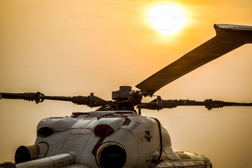 Primo piano dell'elica dell'aeroplano, l'atterraggio di parcheggio dell'elicottero militare sulla piattaforma offshore con sfondo del cielo solare.