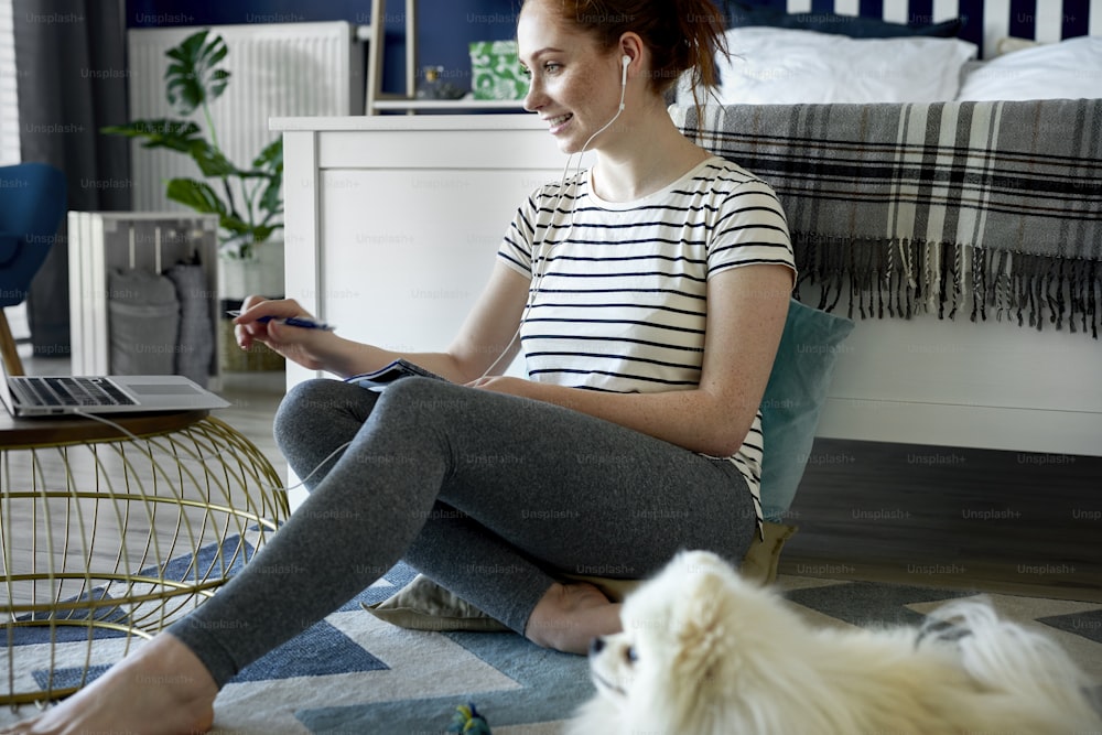 Woman using laptop at home on the floor