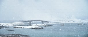 Fredvang pontes em forte queda de neve no inverno com navio de pesca. Ilhas Lofoten, Noruega