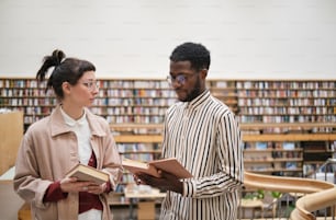 Young couple choosing books in the library