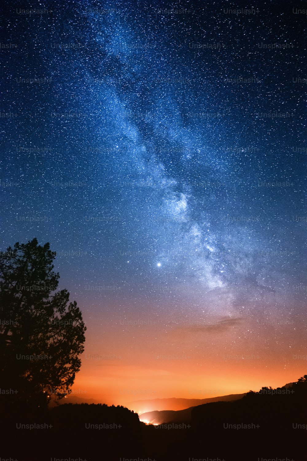 Milky way over the light from the city in the distance. The vast cosmos and reflections on the universe and our place in it.