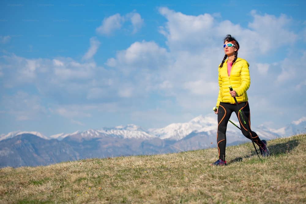 노란 다운 재킷을 입은 소녀가 산을 산책한다