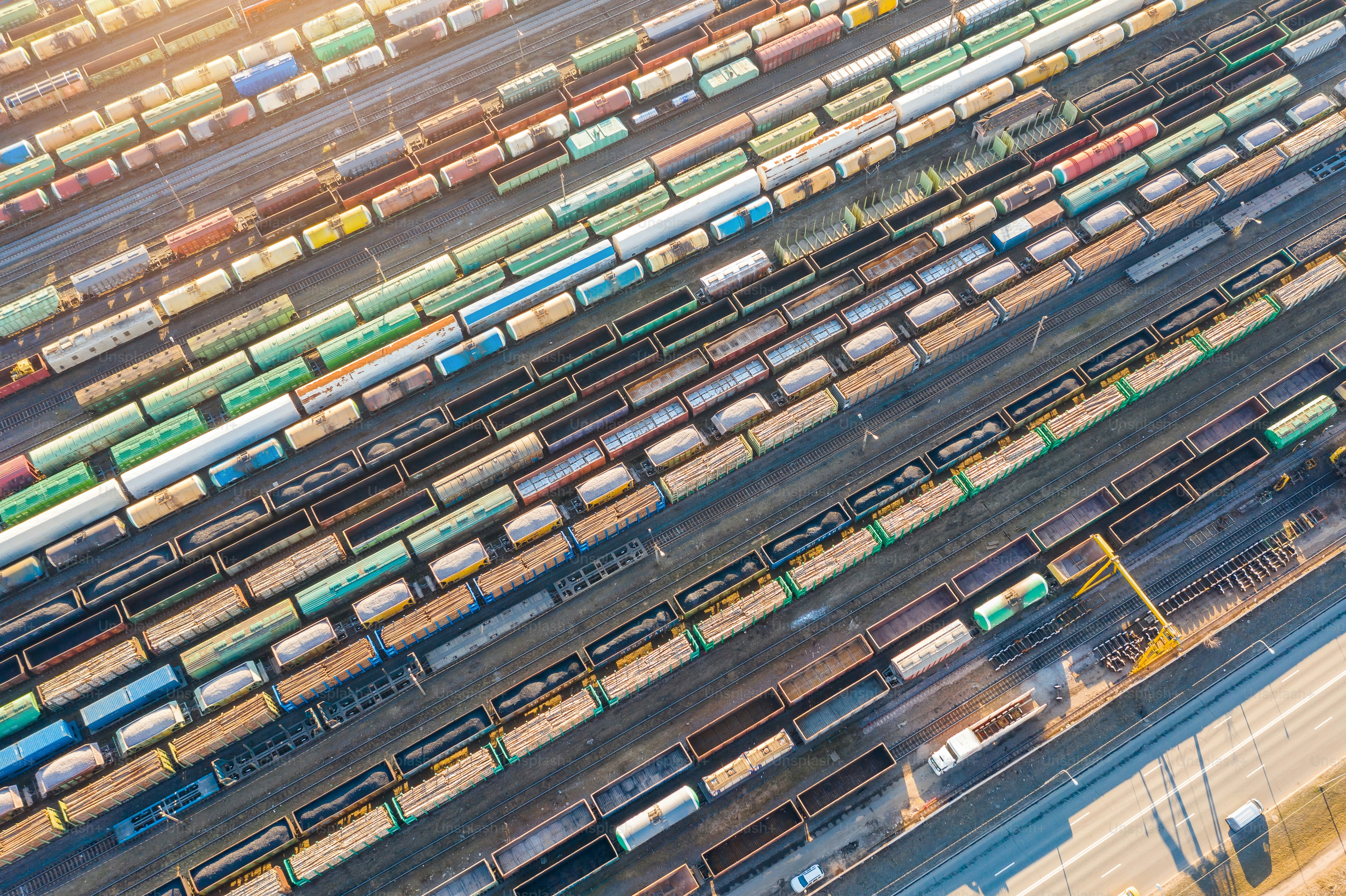 Aerial view of railroad tracks long trains, cargo sorting station. Many different railway cars with cargo and raw materials