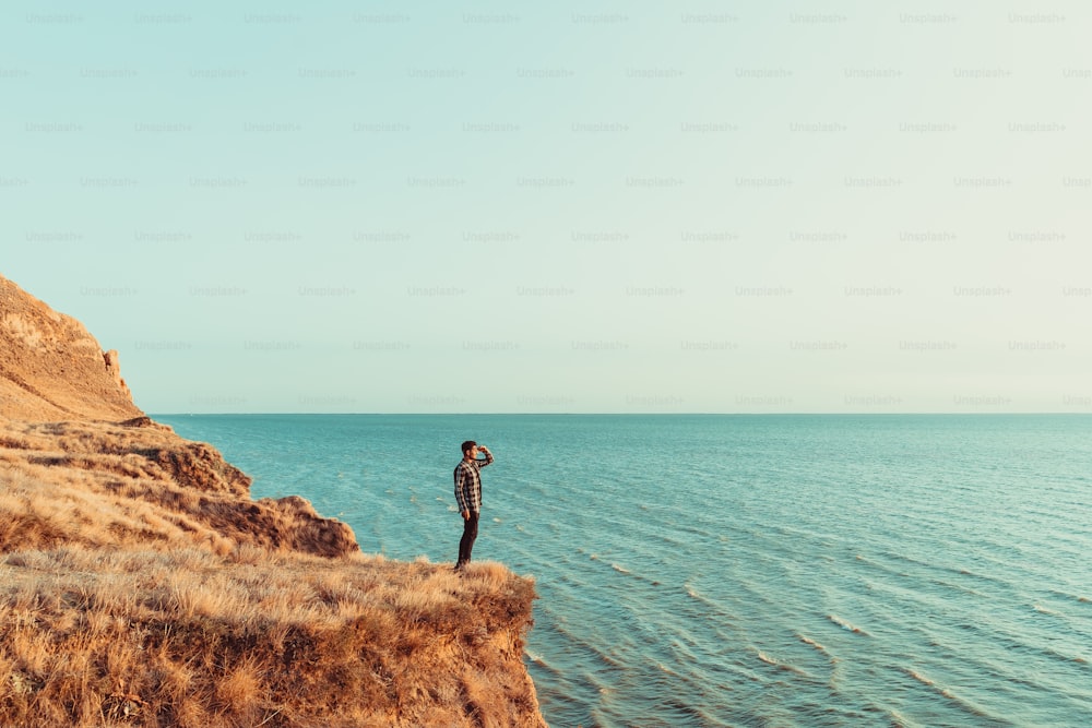 O homem de pé no topo da montanha acima do mar